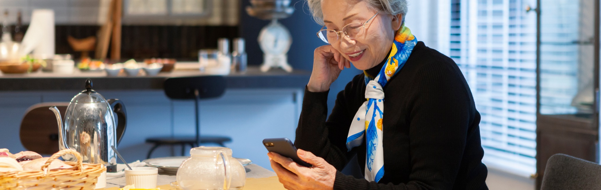 Senior woman operating a smartphone at a cafe